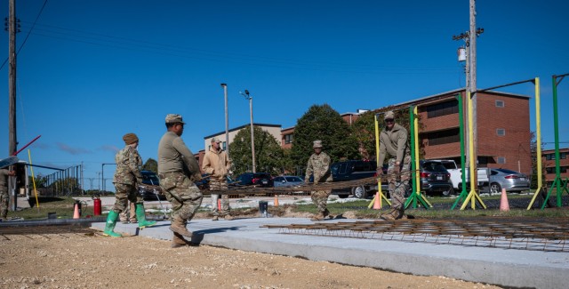 Students with Fort Leonard Wood’s U.S. Air Force 368th Training Squadron Pavements and Equipment Training course move a section of rebar in preparation for Monday’s concrete pour outside the 701st Military Police Battalion’s barracks. The...