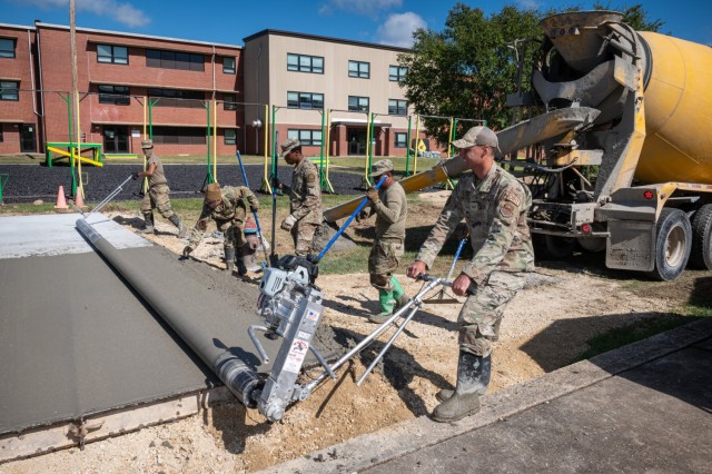 Airmen with Fort Leonard Wood’s U.S. Air Force 368th Training Squadron Pavements and Equipment Training course use a rolling machine to press and smooth the concrete before it sets on Monday outside the 701st Military Police Battalion’s...