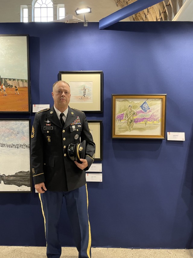 Sgt. 1st Class Jason Spencer at the exhibit with his artwork &#34;Through the Smoke&#34;