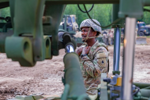 Connecticut Army National Guard Spc. Miracle Sam, a horizontal construction engineer assigned to the 248th Engineer Company, 192nd Engineer Battalion, looks up toward the cab of a grader operated by Spc. Ashano Folkes during annual training at...