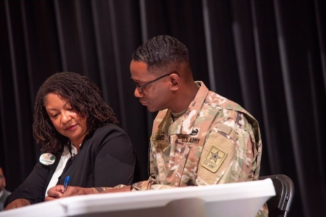 Erica Lewis, Redstone school liaison officer, and her husband, Lt. Col Eric Lewis, sign an Impact Aid form Oct. 12 at Sparkman High School.