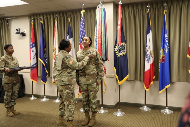 Col. Jeanette Martin, center, director, Enterprise Modernization Directorate, U.S. Army Human Resources Command, pins the Soldier’s Medal on to the chest of Staff Sgt. Aschlynd M. Spidell-Flores, information technology specialist assigned to EMoD, Oct. 20, 2023, during an award ceremony. Spidell-Flores was awarded the medal for risking her life when pulling Dianna McMahan out of her smoldering vehicle Oct. 3, 2022, following a fatal car accident on U.S Route 31W. The Soldier’s Medal is the Army’s highest peacetime award for heroism.