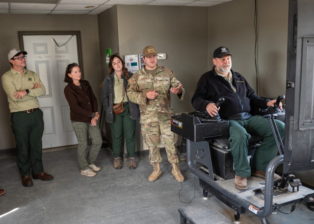 During an Oct. 18 tour of Training Area 244, Air Force Staff Sgt. Devan Gordon, a pavements and equipment training instructor with Fort Leonard Wood’s 368th Training Squadron, explains how the excavator simulator is used to teach Airmen, while...