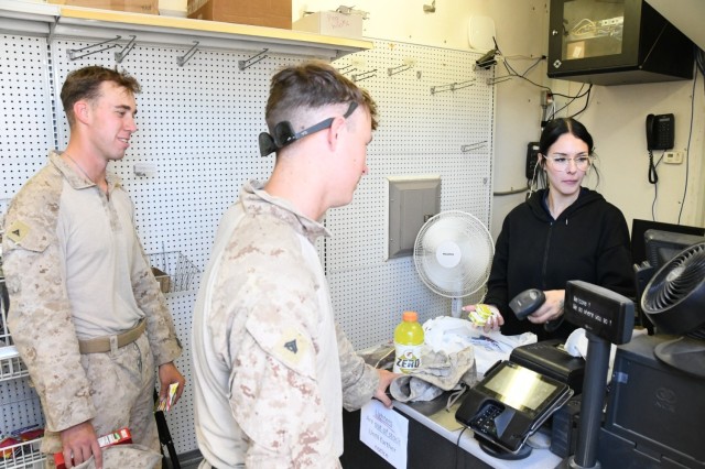 Cashier Rayne Thomas rings up two Marines who made purchases at the Army Air Force Exchange Service (AAFES) Mobile Field Exchange trailer set up at U.S. Army Yuma Proving Ground&#39;s FOB Laguna.