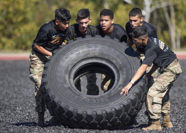 Junior ROTC cadets from Smith-Cotton High School, in Sedalia, Missouri, flip a tire at the 31st Engineer Battalion quad, during the physical team tasks portion of the Raider Challenge event here Saturday.