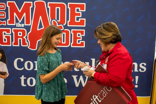 Hannah North receives her gift card Sept. 22 from Maria Berios Borges, the store manager at the Clear Creek Exchange. North was the third-place winner of the AAFES You Made the Grade Program and was awarded a $500 gift card. (U.S. Army photo by Samantha Harms, Fort Cavazos Public Affairs)
