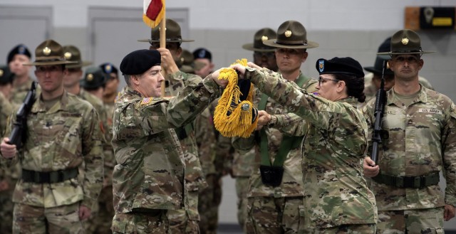 Lt. Col. Thaddeus J. Clark, Task Force Marshall commander, and Command Sgt. Maj. Bethannie J. Bugbee, the unit's senior enlisted advisor, roll up the task force's colors during a ceremony, Oct. 20. Task Force Marshall was stood up in 2004 to train...
