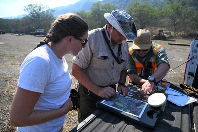 Kaitlyn Lowrance, Field Director, Brian D. Padgett, Ph.D., R.P.A. Archaeologist, and Benjamin Roberts, Cultural Resources Project Director (Contractor), review a map and coordinates to identify cultural heritage assets. They discuss safe zones with the 425th Civil Affairs team during the JPMRC rotation.