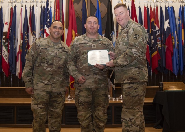 Maj. Gen. Christopher Beck, Maneuver Support Center of Excellence and Fort Leonard Wood commanding general (right), and MSCoE and Fort Leonard Wood Command Sgt. Maj. Jorge Arzabala (left), pose for a photo Wednesday in Lincoln Hall Auditorium with...