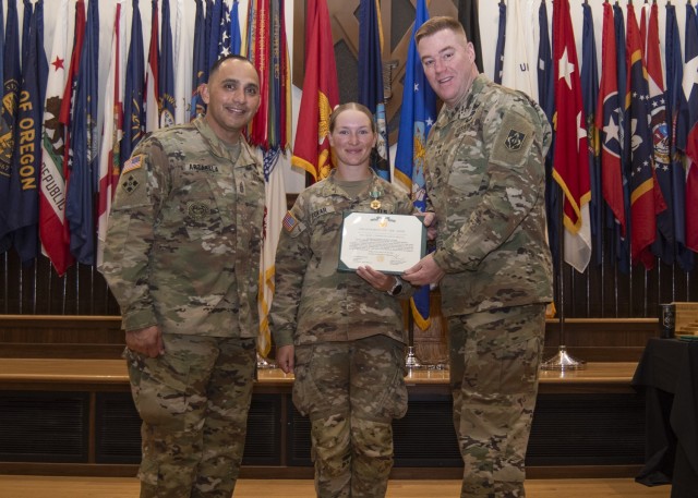 Maj. Gen. Christopher Beck, Maneuver Support Center of Excellence and Fort Leonard Wood commanding general (right), and MSCoE and Fort Leonard Wood Command Sgt. Maj. Jorge Arzabala (left), pose for a photo Wednesday in Lincoln Hall Auditorium with...