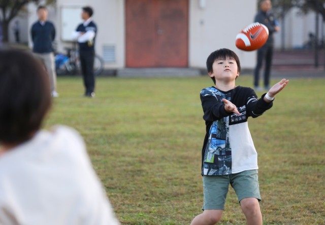 A Japanese elementary school student catches a football during a youth sports clinic at Sagamihara Family Housing Area, Japan, Nov. 3, 2023. The clinic, which had about 150 American and Japanese children attend, was the first event jointly hosted by U.S. Army Garrison Japan and Zama Junior Chamber International. 