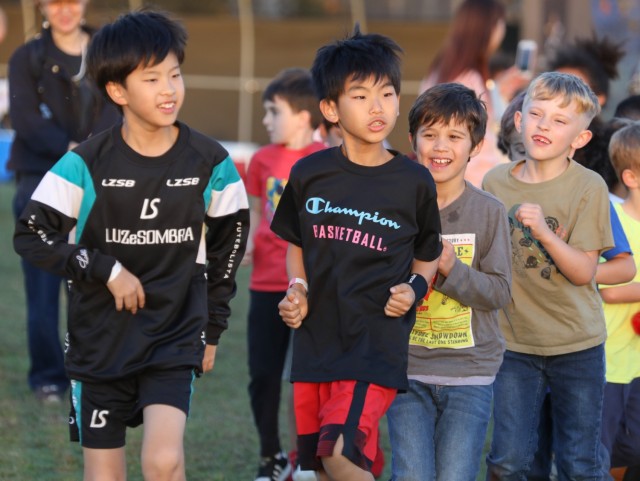 2023年11月3日、日本の坂見原ファミリー住宅地区で行われた青少年スポーツクリニックで準備運動をするアメリカ人と日本の子供たち。 在日米陸軍駐屯地が主催する初めてのイベントで、クリニックには約１５０人の子どもたちが参加した。  JAMA青年会議所。 