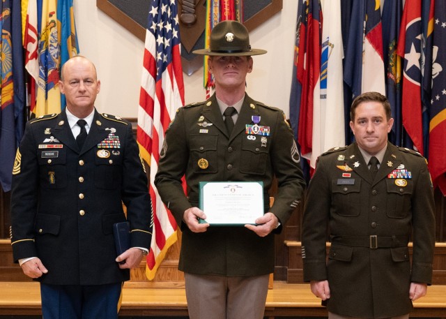 1st Psychological Operations Battalion Command Sgt. Maj. James Roscoe, left, and Lt. Col. Jeffrey Reed, 1st Psychological Operations Battalion commander, right, present Staff Sgt. Ryan Johnson, center, with a Purple Heart medal during a ceremony...