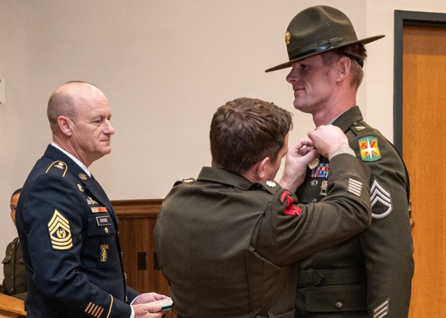 Lt. Col. Jeffrey Reed, 1st Psychological Operations Battalion commander, pins a purple heart to Staff Sgt. Ryan Johnson’s chest during a Purple Heart presentation ceremony held Friday in Lincoln Hall Auditorium. Johnson is currently a drill...