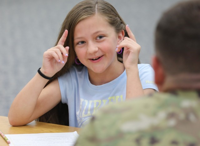 Charlotte Hansen, a fourth grader at Arnn Elementary School, asks a question to Chief Warrant Officer 3 Eddie Saldarini, a support operations maintenance officer assigned to the 35th Combat Sustainment Support Battalion, while interviewing him as part of a school project at Sagamihara Family Housing Area, Japan, Nov. 7, 2023.