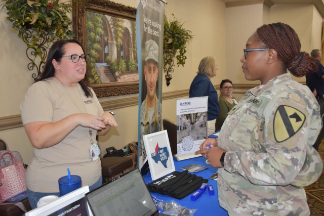 Spc. Shakera King, 115th Brigade Support Battalion, 1st Armored Brigade Combat Team, speaks with a representative from Samsung at the annual Red, White and You Career Fair Nov. 1 at the Lone Star Conference Center at Fort Cavazos. The event is one of the three major career fairs held annually at Fort Cavazos. (U.S. Army photo by Janecze Wright, Fort Cavazos Public Affairs)