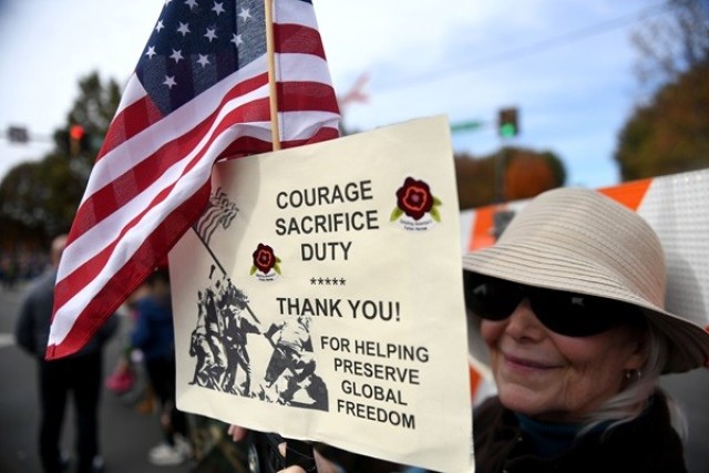 Patti Wilson, of Huntsville, carries a sign during the 2023 Veterans Day Parade in downtown Huntsville on Saturday. 