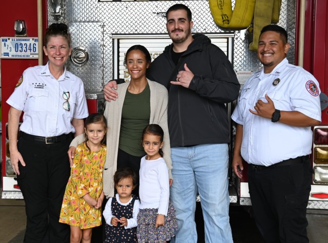 First responders from the Federal Fire Department, local EMS, and the Hawaii Fire Department gather, exemplifying the successful collaboration that saved Sergeant Dustin Charles Woodmansee&#39;s life. Key figures, including Mateo Mariano and Shalei Meneses, are pictured alongside Sgt. Woodmansee and his wife, Brittany. This powerful image captures the spirit of unity and dedicated service that defines their life-saving mission under mutual aid agreements.