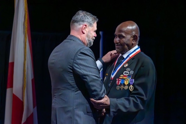 Retired Cmdr. Clay Davis, president of the Madison County Military Heritage Commission, presents a medal to Ronald Wright during his induction into the Hall of Heroes at the Veterans Dinner Nov. 10. 