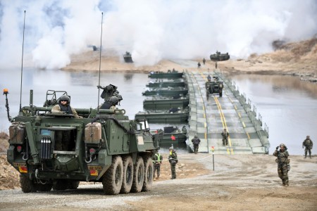 Soldiers drive a Stryker vehicle over a temporary floating bridge during wet gap training on the Imjin River, South Korea, March 15, 2023. During training, soldiers honed skills for crossing water obstacles while strengthening the U.S. and South Korean combined defense posture.