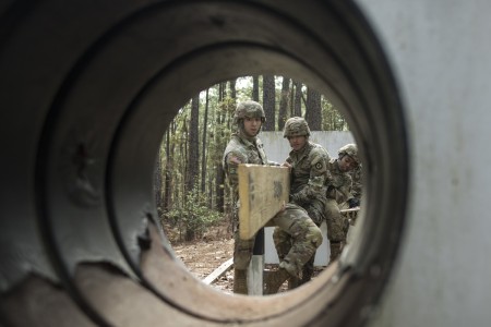 Spc. Stephon Mixter (left), Pfc. Robert Broughton (middle) and Pfc. Courtney Young (right) places a board to traverse at the Leader Reaction Course during the Combined Brigade Best Squad Competition here in McCrady Training Center, South Carolina....