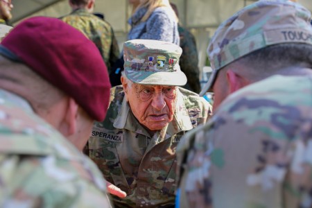 World War II Veteran, Vincent Speranza speaks with Soldiers assigned to the 173rd Airborne Brigade and 207th Military Intelligence Brigade (Theater) before the D-Day 79 Airborne drop on the Iron Mike Drop Zone. 45 Soldiers performed high altitude free fall jumps, their breathtaking display captivated veterans, Soldiers and civilians alike.