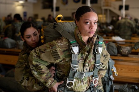 U.S. Army Spc. Destiny Clark and Spc. Kennia Lopez, both paratroopers assigned to the 4th Quartermaster Company, 725th Brigade Support Battalion (Airborne), 2nd Infantry Brigade Combat Team (Airborne), 11th Airborne Division, don parachutes ahead of an all-women jump at Joint Base Elmendorf-Richardson, Alaska, March 7, 2023. The airborne operation was held in recognition of Women’s History Month and marked the first all-female jump in division history.