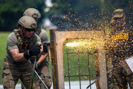 Capt. Aaron Dominic, a Soldier assigned to the 2nd Battalion, 23rd Infantry Regiment, 1st Stryker Brigade Combat Team, 4th Infantry Division cuts through an obstacle designed to simulate a steel-reinforced window during the Best Ranger Competition at Columbus, Georgia, on April 15, 2023.