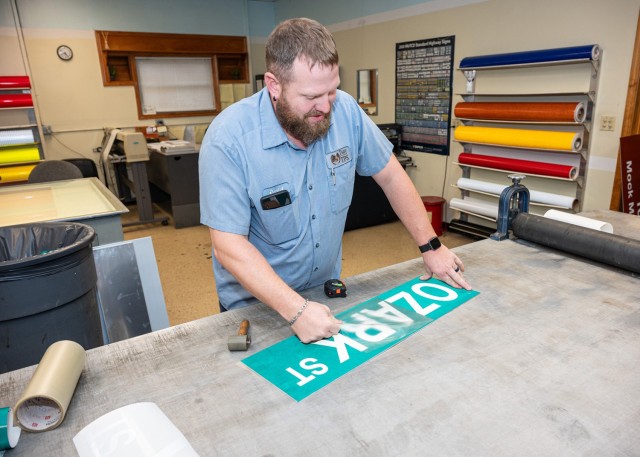 Danny Trusty, a Fort Leonard Wood sign specialist, works on one of the new street signs set to be installed by Jan. 1. Fort Leonard Wood is changing three street names, in line with a Department of Defense Naming Commission initiative. The streets...