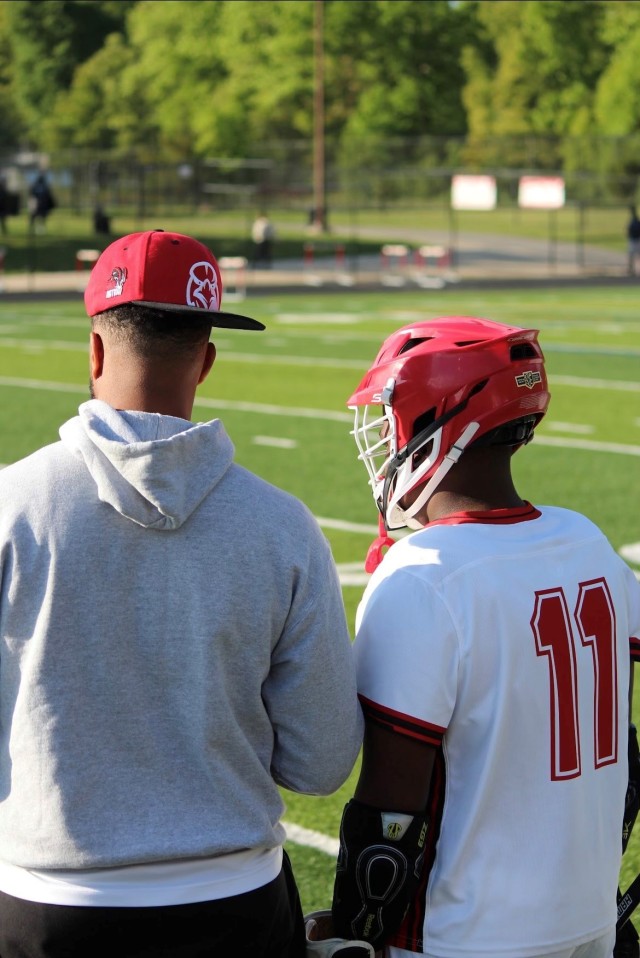 Rick Burton, a patent security specialist for U.S. Army Combat Capabilities Development Command, or DEVCOM, left, prepares to substitute an Edgewood High School lacrosse player into the game May 5, 2023, at Edgewood High School in Edgewood, Maryland. Burton serves as the team’s coach. 