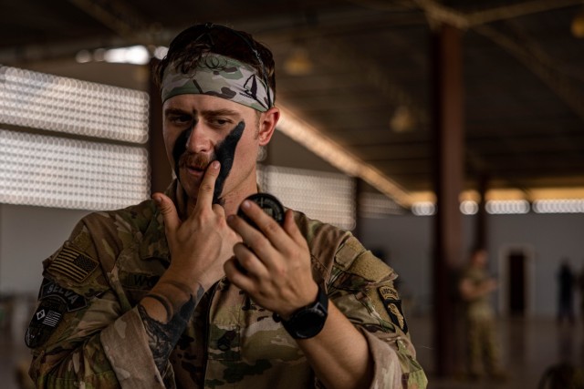 A U.S. Army Soldier assigned to 1st Battalion, 26th Infantry Regiment, 2nd Brigade Combat Team, 101st Airborne Division (Air Assault) applies face paint before an air assault operation in Amapá, Brazil, during Exercise Southern Vanguard 24, Nov. 8, 2023. Southern Vanguard, an annual bilateral exercise which rotates between partner nations in the U.S. Southern Command area of responsibility, is designed to enhance partner interoperability between the U.S. and partner nation forces. (U.S. Army photo by Spc. Joshua Taeckens)
