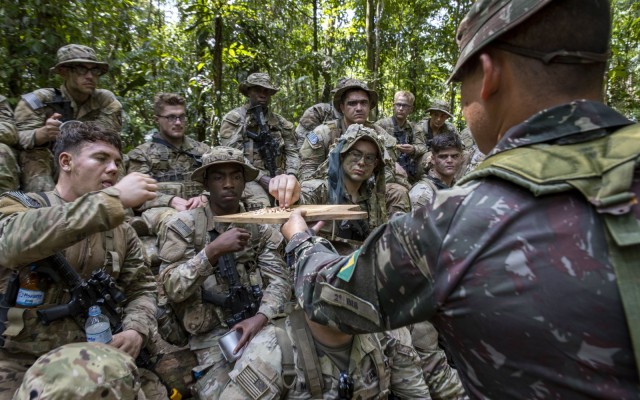 Soldiers assigned to the 101st Airborne Division (Air Assault) sample an abiu fruit at a basic Brazilian jungle familiarization course ahead of Southern Vanguard 24 in Belem, Brazil, Nov. 02, 2023. Southern Vanguard 24 is an annual bilateral exercise designed to enhance partner interoperability between participating U.S., Brazil and Partner Nation forces. (U.S. Army National Guard photo by Staff Sgt. Jonathan Pietrantoni)