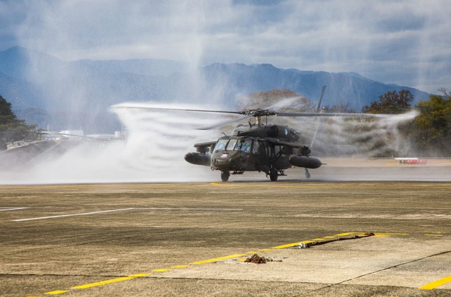 A UH-60 Black Hawk helicopter flown by Chief Warrant Officer 4 Rick Dean, assigned to U.S. Army Aviation Battalion–Japan, is sprayed with water after Dean&#39;s final flight at Camp Zama&#39;s Kastner Airfield in Japan, Dec. 1, 2023. Dean served 26 years in the Army, much of them as a helicopter pilot.