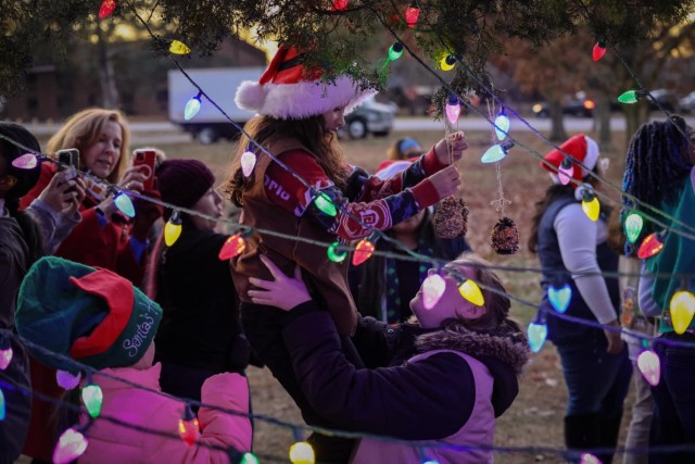 Girl Scouts place ornaments on the tree Thursday, Nov. 30, 2023 at the Fort Gregg-Adams Grand Illumination.