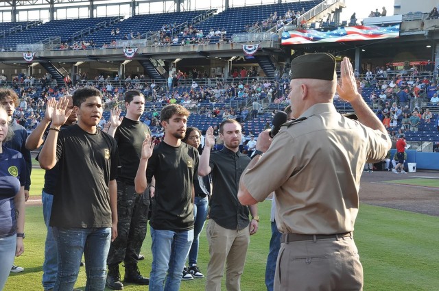 Maj. Gen. John Kline, commander of the U.S. Army Center for Initial Military Training, swears in 25 Army recruits at a Norfolk Tides Armed Forces Night baseball game in Norfolk, Virginia.