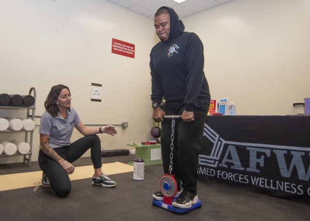 Myka Kerr, a health educator with Fort Leonard Wood’s Armed Forces Wellness Center, assists Spc. Derrick Waller, with 2nd Battalion, 10th Infantry Regiment, with measuring his back strength at a holistic health and fitness clinic Saturday at...