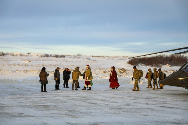 Santa and fellow Operation Santa Claus volunteers greet community members as they exit an Alaska Army National Guard UH-60L Black Hawk near the Inupiat Eskimo village of Golovin Nov. 30, 2023. Operation Santa Claus is the Alaska National Guard’s annual community outreach program that provides gifts and Christmas cheer to children in remote communities. (Alaska National Guard photo by 1st Lt. Balinda O’Neal)