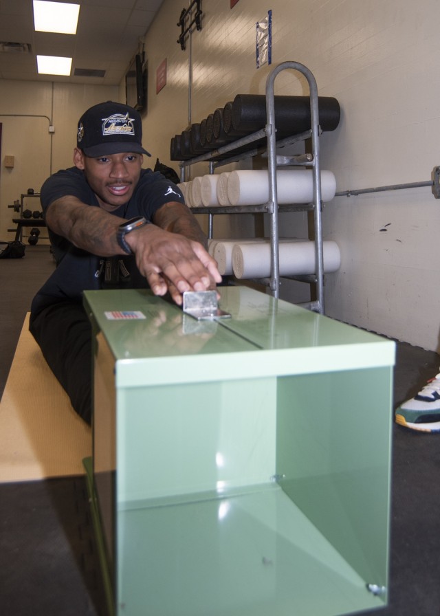 Spc. Dewayne Lewis, with Headquarters and Headquarters Company, 1st Engineer Brigade, tests his flexibility at a holistic health and fitness clinic Saturday at Cunningham Gym.