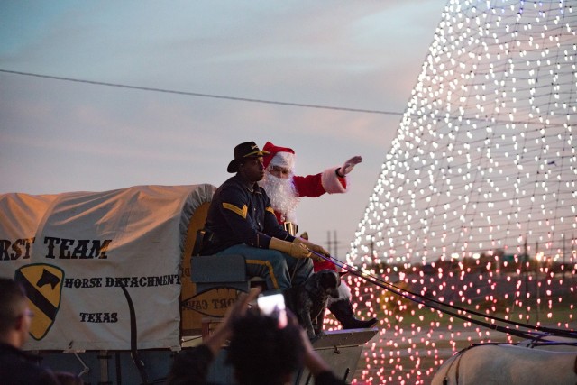 Santa, escorted by members of the 1st Cavalry Division Horse Detachment, waves to attendees Dec. 1.  (U.S. Army photo by Blair Dupre, Fort Cavazos Public Affairs)