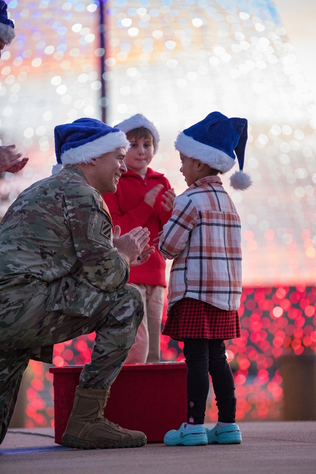 Lt. Gen. Sean C. Bernabe, III Armored Corps and Fort Cavazos commanding general, smiles at Mariah Fletcher, 5, with Joseph Brooks, 8, looking on, after successfully lighting the tree during the annual Holiday Tree Lighting Ceremony Dec. 1. (U.S. Army photo by Blair Dupre, Fort Cavazos Public Affairs)
