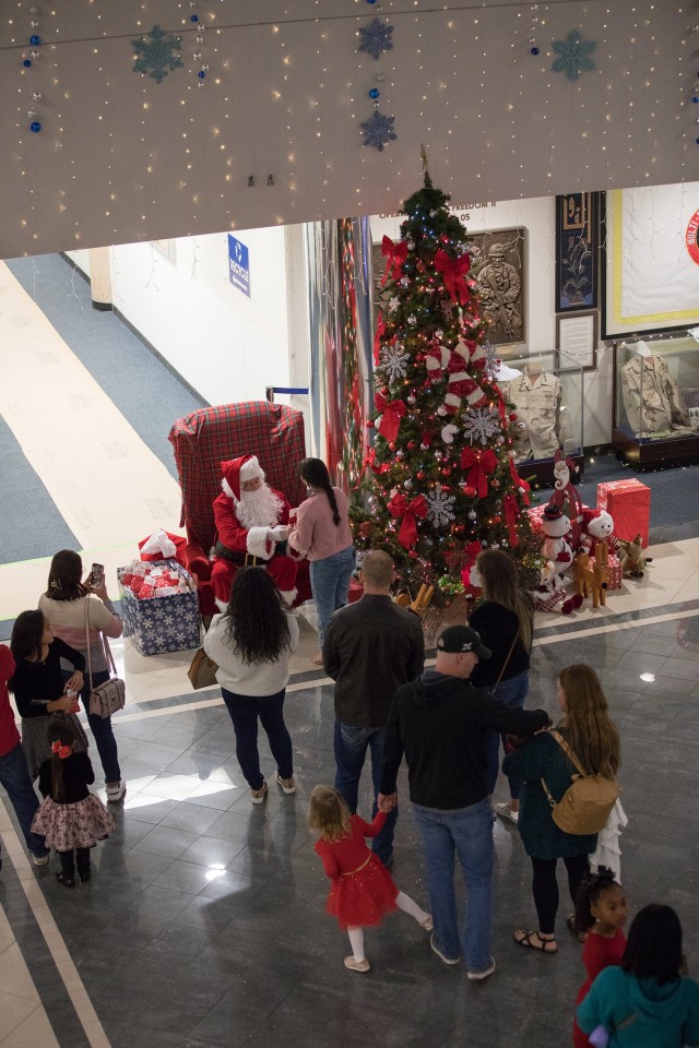 Santa speaks to families and poses for photos Dec. 1 in the East Atrium of the III Armored Corps Headquarters. (U.S. Army photo by Blair Dupre, Fort Cavazos Public Affairs)