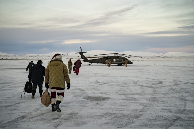 Santa, Mrs. Claus and Operation Santa Claus volunteers prepare to board an Alaska Army National Guard UH-60L Black Hawk helicopter in Nome, Alaska, Nov. 30, 2023. From Nome, the journey continued 70 miles east via UH-60L Black Hawk helicopter to the Inupiat Eskimo village of Golovin. Operation Santa Claus is the Alaska National Guard’s yearly community outreach program that provides gifts and Christmas cheer to children in remote communities across the state.