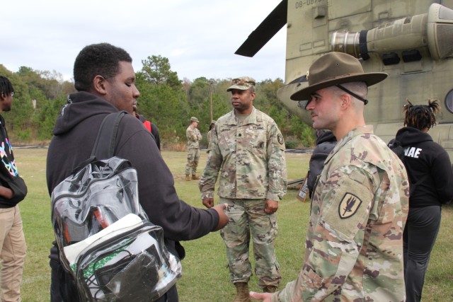 Drill Sergeant (Sgt. 1st Class) Kristian Jimenez, 1-13th Aviation Regiment, Fort Novosel, talks with a student from Hillcrest High School in Conecuh County, Alabama at the Hometown Heroes Army Recruiting event on Dec. 8, 2023.
