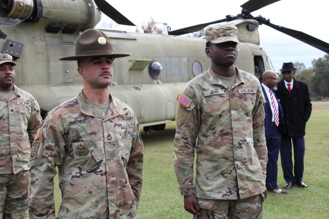 Drill Sergeant (Sgt. 1st Class) Kristian Jimenez stands at attention during the promotion of Pvt. Dusenge Jean-Chrisostome from E-1 to E-2 at Hillcrest High School in Conecuh County, Alabama at the Hometown Heroes Army Recruiting event on Dec. 8,...