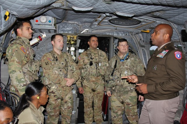 Col. Sherdrick Rankin, 2nd Recruiting Brigade Commander, presents coins to the CH-47 crew, led by Cpt. Berry, Chief Warrant Officer Rios, Staff Sgt. Buys, and Staff Sergeant Cox from 110th Aviation Brigade at Hillcrest High School, in Conecuh...
