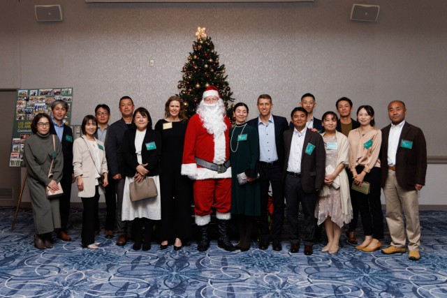 Col. Marcus Hunter, commander of U.S. Army Garrison Japan, and his wife, Caren, take a photo with Japan Ground Self-Defense Force members during a holiday reception inside the Camp Zama Community Club at Camp Zama, Japan, Dec. 8, 2023. More than...