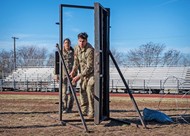 Performing a door breach at the 36th Engineer Brigade’s Rugged Best Sapper Competition here Dec. 7 is 2nd Lt. Steven Rega and 1st Lt. Monica Eckford, with the 62nd Engineer Battalion at Fort Cavasos, Texas. The breaching was part of the final...