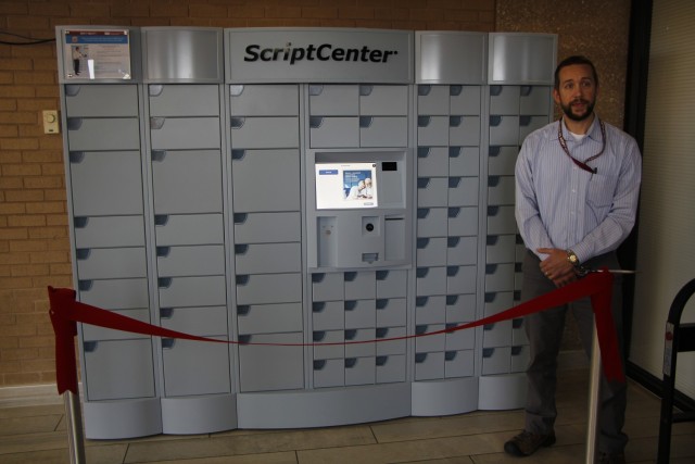 Reynolds Army Health Clinic pharmacy chief Dr. Matthew Desmarais stands in front of the newly installed ScriptCenter kiosk.