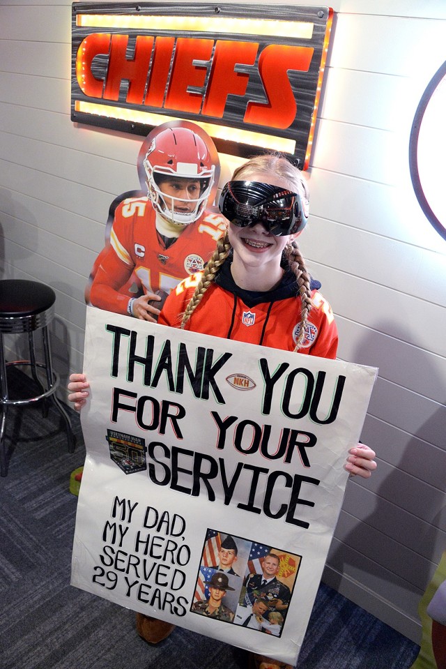 Thirteen-year-old Maddie Fuller, aka KC Chiefs Goggle Girl, holds a sign she made to honor her father and Chiefs game day buddy, retired Command Sgt. Maj. Mike Fuller, near a Patrick Mahomes cutout, a Christmas gift for Mike, Nov. 30 in the Fuller...