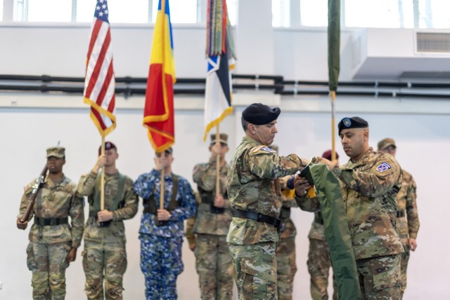 Maj. Gen. Gregory K. Anderson, commander of the 10th Mountain Division, "Task Force Mountain", and Sgt. Maj. Jorge Rivera, operations sergeant major for 10th Mountain Division, case the division colors during the transfer of authority ceremony, between 10th Mountain Division, "Task Force Mountain", to 82nd Airborne Division, "Task Force 82", hosted by the U.S. Army’s V Corps, at Mihail Kogalniceanu Air Base, Romania, Dec. 15. (U.S. Army Photo by Sgt. 1st Class Jonathan Hornby).